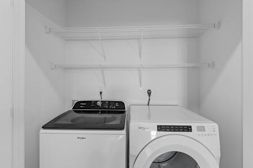 A Whirlpool washing machine and dryer in a laundry room  at Tivoli Green Apartments & Townhomes, Mount Pleasant, WI, 53406
