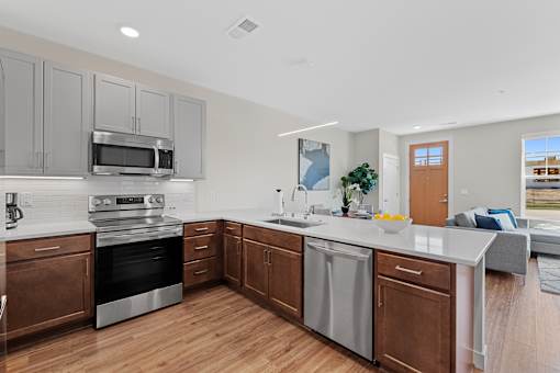 A modern kitchen with wooden cabinets and stainless steel appliances  at Tivoli Green Apartments & Townhomes, Mount Pleasant, Wisconsin, 53406