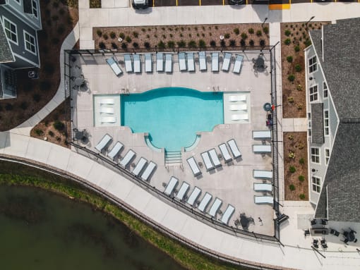 an aerial view of a swimming pool with lounge chairs around it