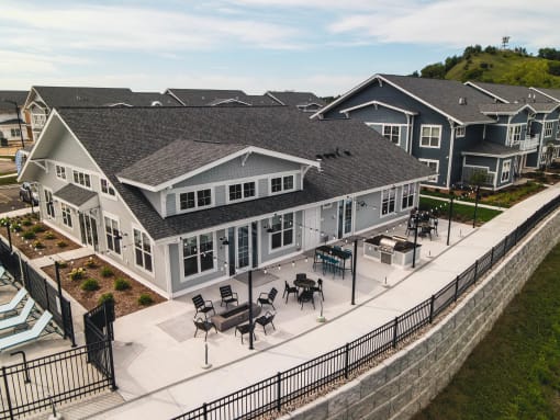 an aerial view of a large house with tables and chairs in the yard