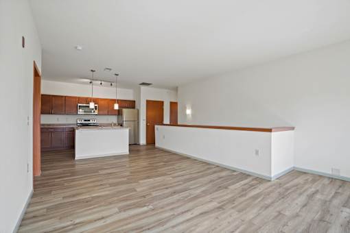 A large empty room with wooden floors and white walls.