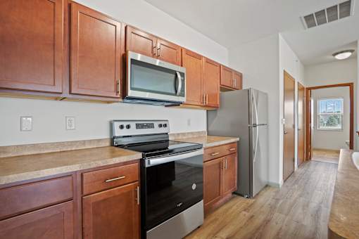 A kitchen with wooden cabinets and stainless steel appliances.