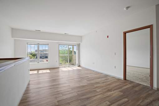 A room with wooden flooring and a large mirror on the wall.