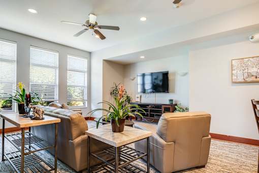 A living room with a television, two chairs, and a table.
