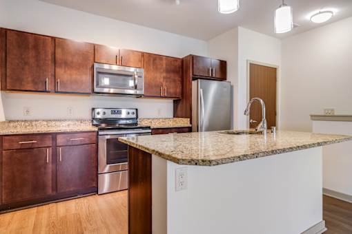 A kitchen with brown cabinets and a granite countertop.
