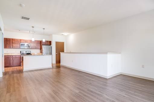 A large empty room with wooden floors and white walls.