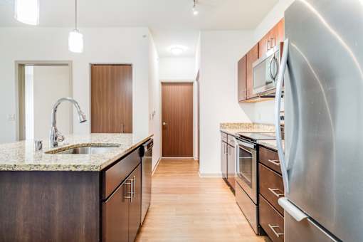 A kitchen with a granite countertop and stainless steel appliances.
