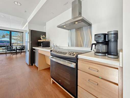 The Stryker Senior Apartments in West St. Paul Community Room kitchen with a stove, oven, and a coffee maker.