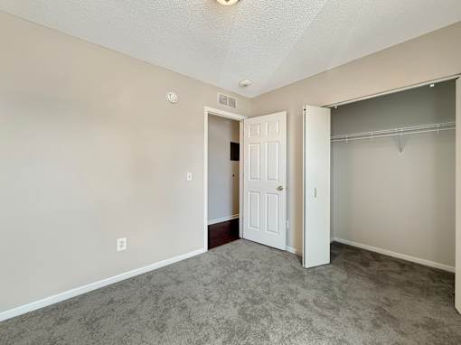 A room with a carpeted floor and a white door.