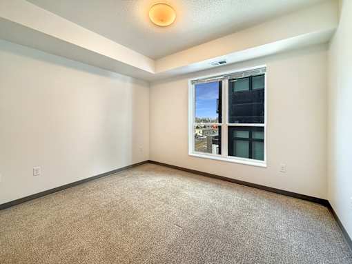 A room with a window and carpeted floor.