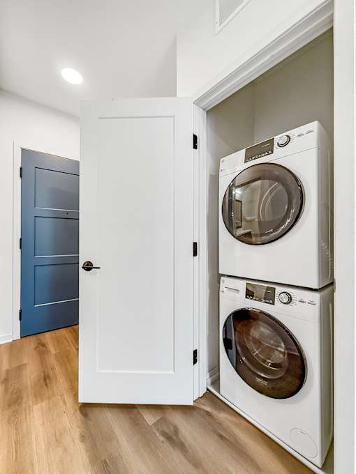A white cabinet with two washing machines stacked on top of each other.