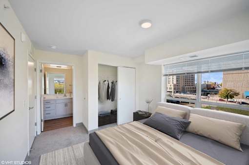 A bedroom with a large bed and a view of the city.