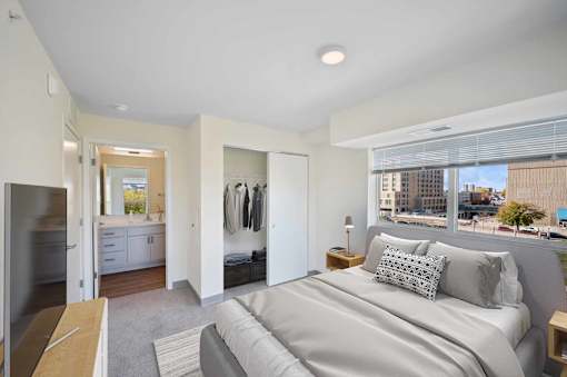A bedroom with a large bed and a view of the city.
