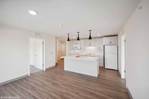 A kitchen with white appliances and a white island.