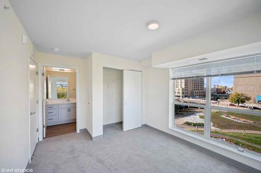A spacious, empty room with a view of the city outside the window.