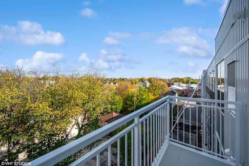 A balcony with a metal railing overlooks a cityscape.
