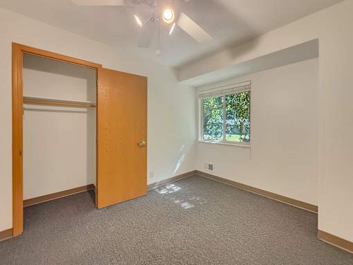 A room with a ceiling fan and a window.