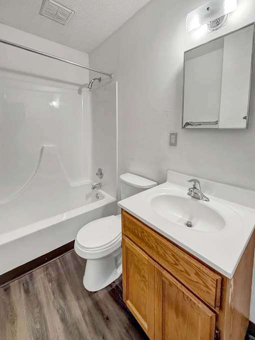 A white toilet sits next to a white sink in a bathroom.