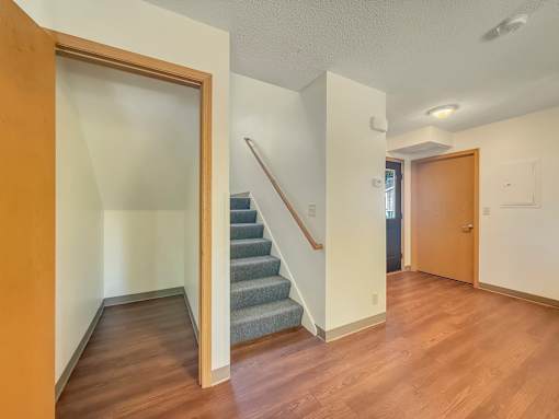 A hallway with a staircase and two doors.