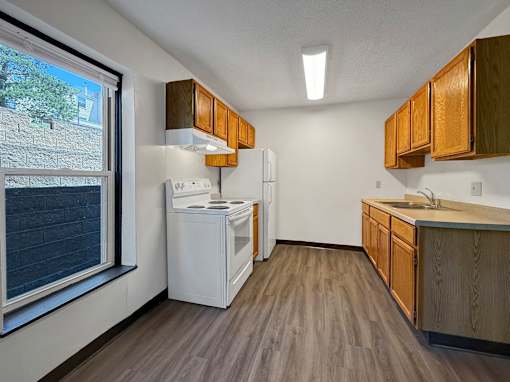A kitchen with wooden cabinets and a white refrigerator.