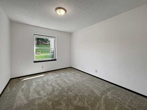 A room with a window showing a green lawn outside.