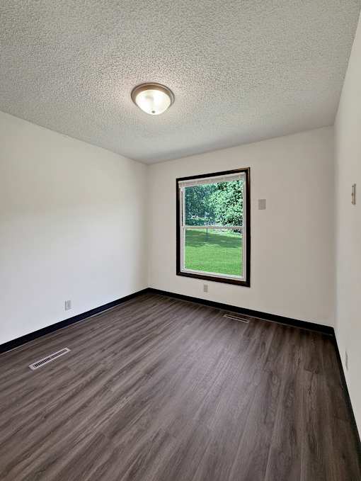 A room with a window showing a green lawn outside.