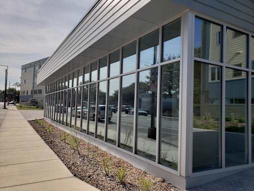the side of a building with windows and a sidewalk