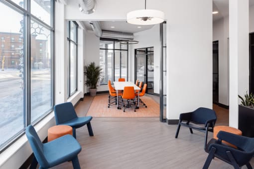 a conference room with a table and chairs and large windows