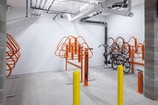 the bike rack in the new building has been updated with orange poles and a wall