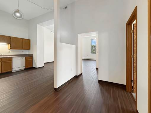 A long hallway with a brown floor and white walls.