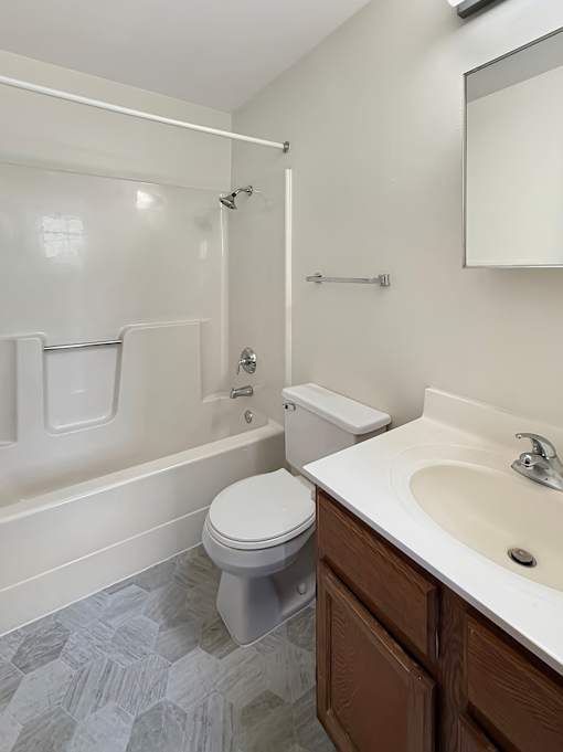 A white toilet sits in a bathroom next to a sink.