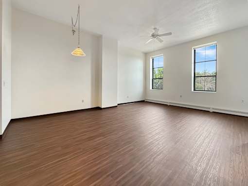 A room with wooden flooring and a ceiling fan.