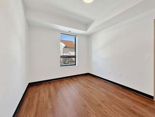 Another Stryker Senior Apartments in West St. Paul bedroom with wooden floor and a window.