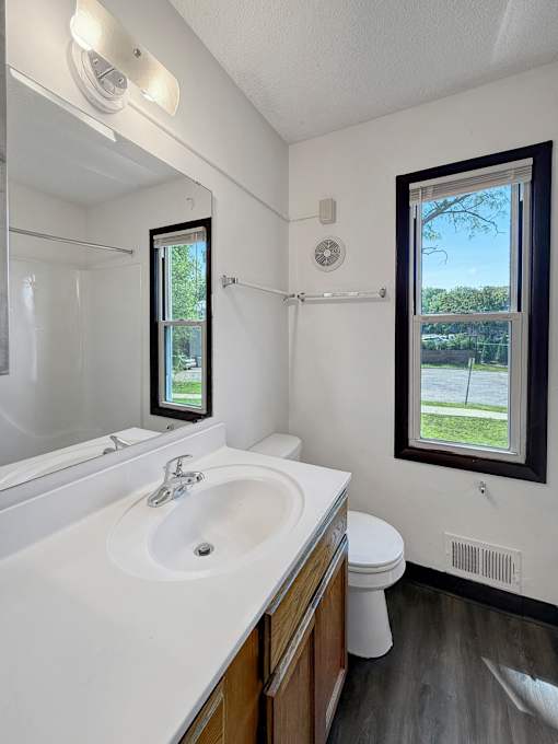 A bathroom with a white sink and a window.