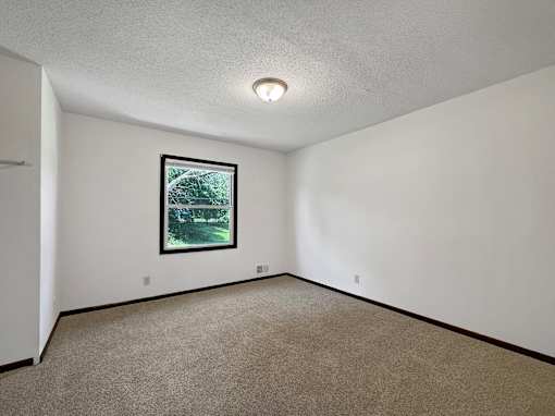 A room with a framed picture on the wall and carpeted floor.