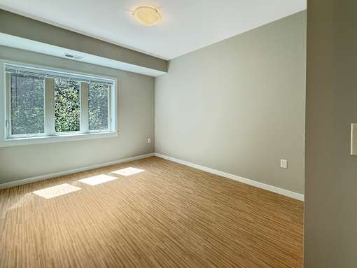 A room with a window and wooden flooring.