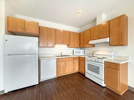 A kitchen with wooden cabinets and white appliances.