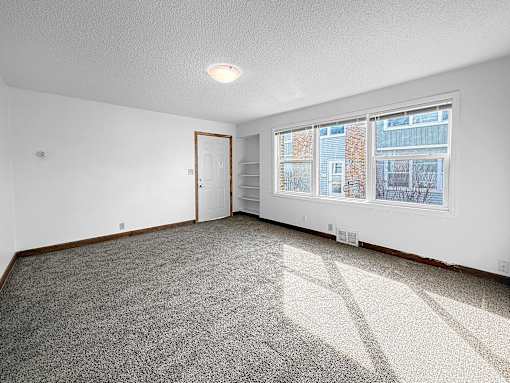 A living room with front door and large window