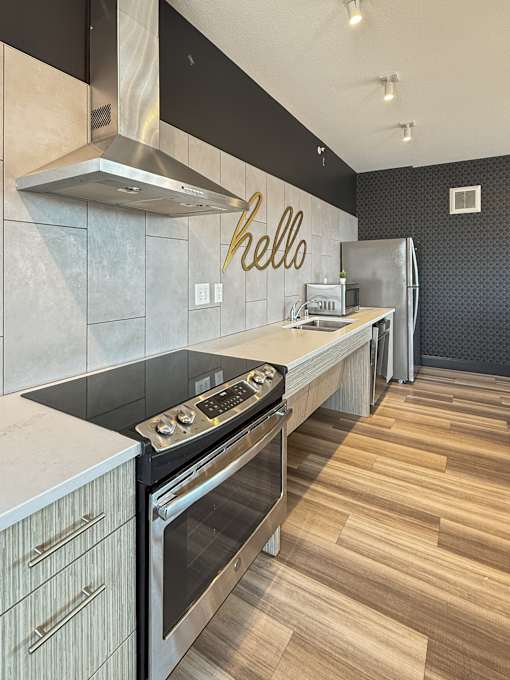 A modern kitchen with a stove top oven and a refrigerator.
