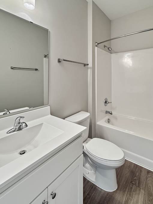 A white toilet sits next to a white sink in a bathroom.