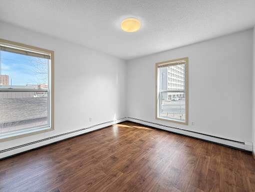 A room with a window and a wooden floor.