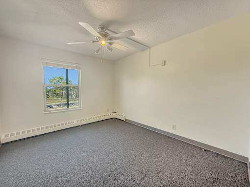 A room with a ceiling fan and a window.