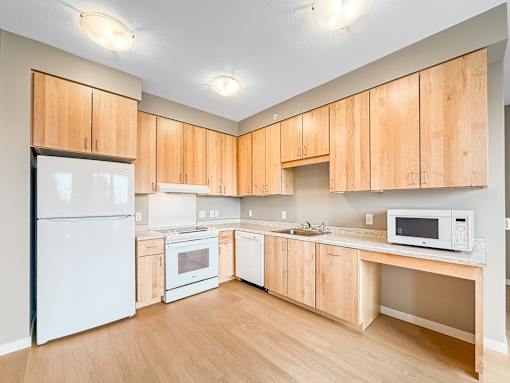 A kitchen with wooden cabinets and white appliances.