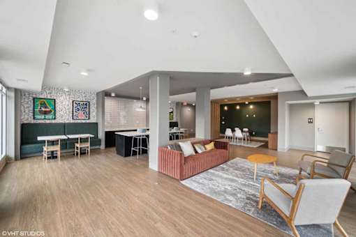 A living room with a couch, chairs, and a rug.