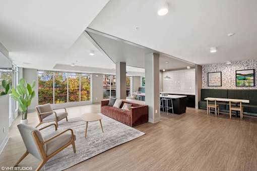 A living room with a couch, chairs, and a rug.