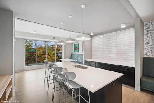 A modern kitchen with a large island and chairs.
