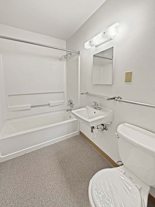 A white bathroom with a toilet, sink, and bathtub.
