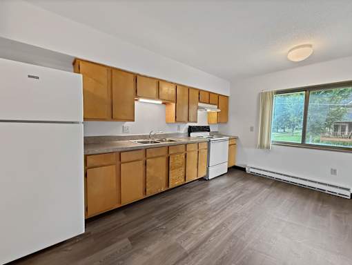 A kitchen with wooden cabinets and a white refrigerator.