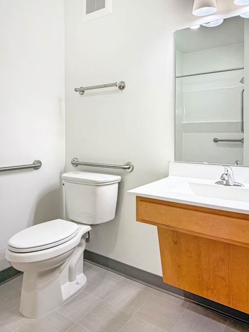 A white toilet sits next to a sink in a bathroom at The Lumin in the Highland Park neighborhood of St Paul.