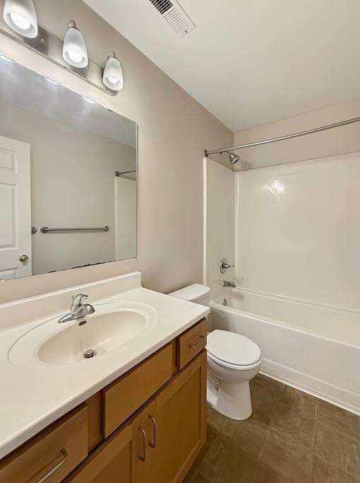 A bathroom with a sink, toilet, and bathtub.